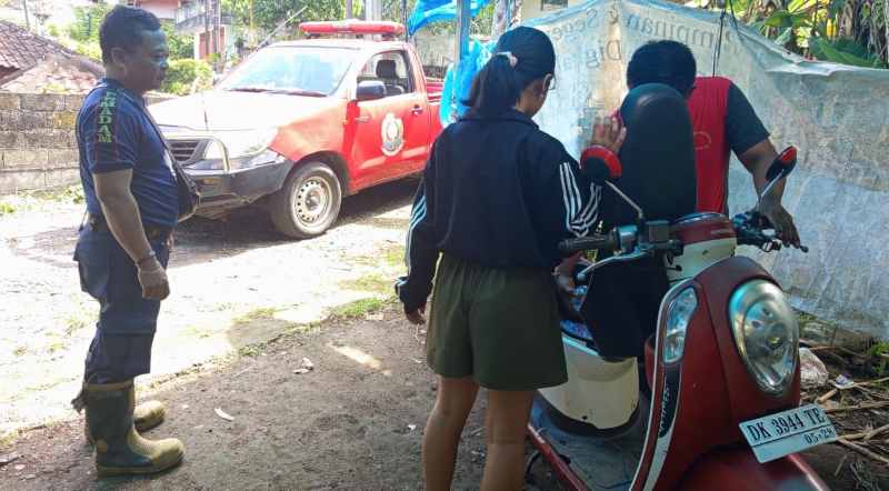 SEMAKIN DIAKRABI WARGA: Petugas Dankartan saat membantu salah seorang remaja yang meminta pertolongan mengambil kunci tertinggal di dalam bagasi motor.( Foto Damkartan Karangasem)