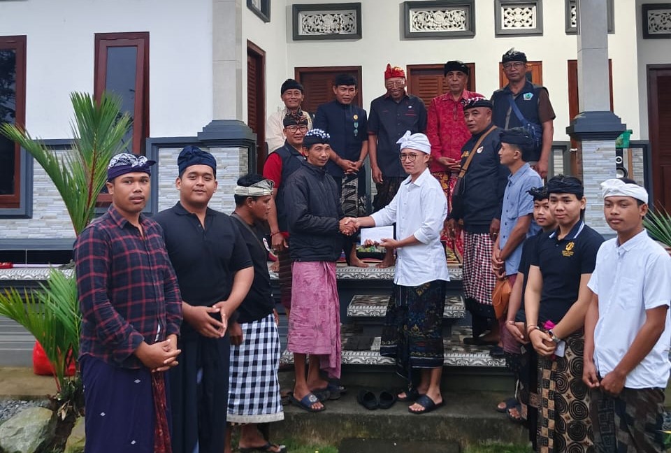 MOTIVASI: Nengah Wartawan, pecalang Desa Adat Besakih yang menjadi korban pengeroyokan saat bertugas dalam Yadnya Bhatara Turun Kabeh Pura Agung Besakih, terima santunan.