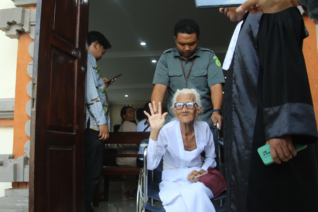 SEMPATKAN MENYAPA: Ni Nyoman Reja sesaat sebelum disidangkan di PN Denpasar, Selasa (27/5/2025).