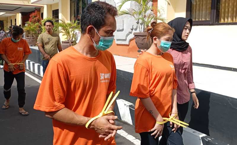 TERTANGKAP: UJ dan SN digiring polisi. UJ yang masuk DPO ditangkap bersama dengan SN dan RM di Desa Cempaga, Kecamatan Banjar, Kabupaten Buleleng.(Francelino Junior)