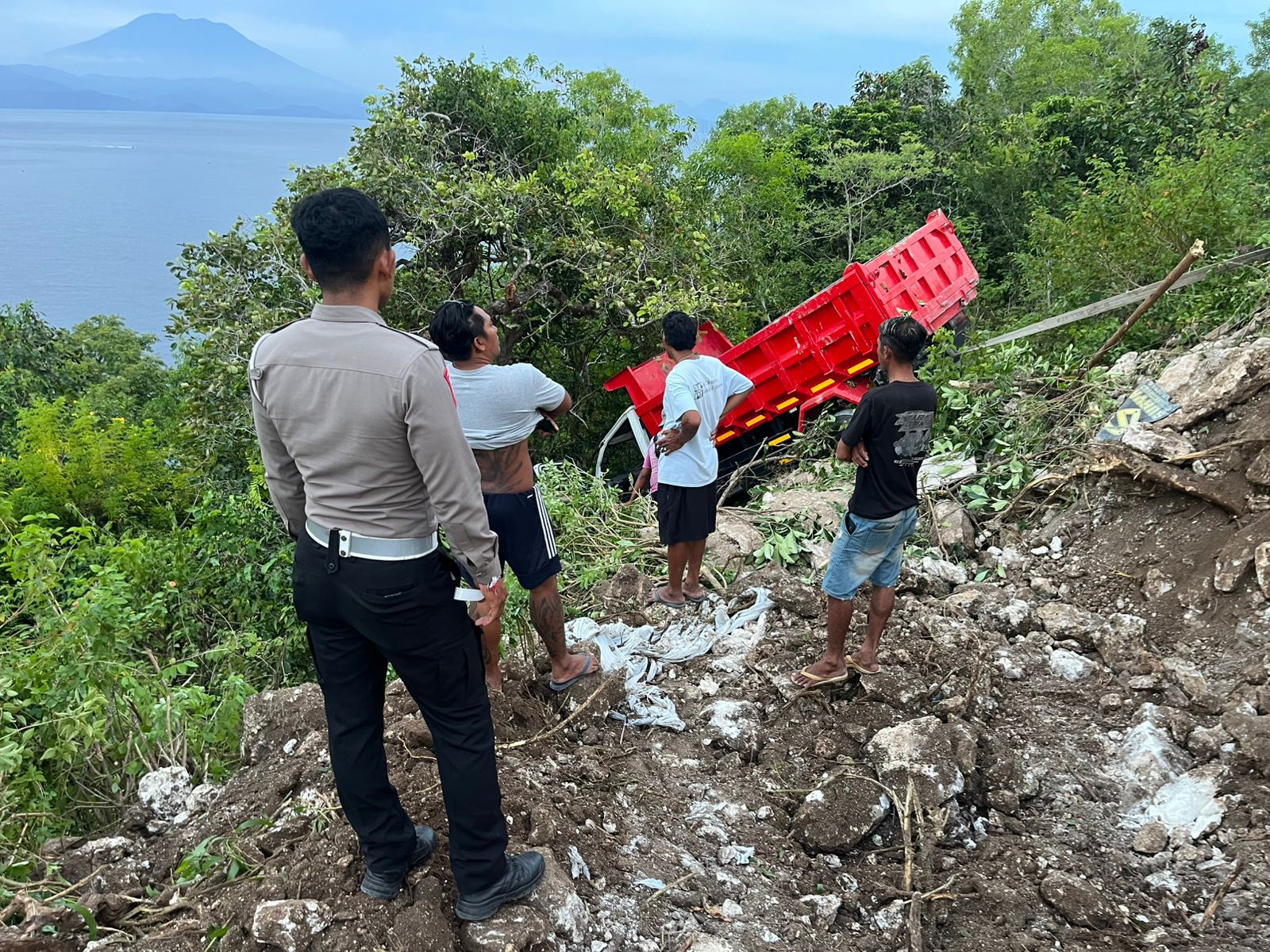 NYARIS NYEMPLUNG:  truk Isuzu DK 8062 YG mengangkut material tanah uruk terperosok ke jurang  di Nusa Penida