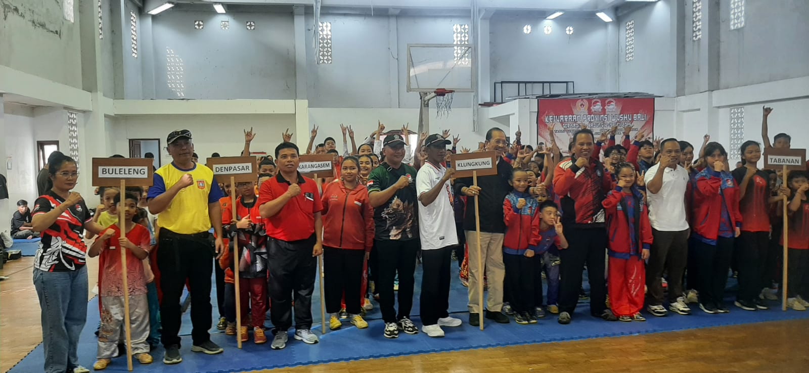 HARUS SPORTIF: Ketua KONI Bali Oka Dharmawan berada disela para peserta Kejurprov Wushu Bali 2025 saat defile pembukaan di GOR Basket Sading.