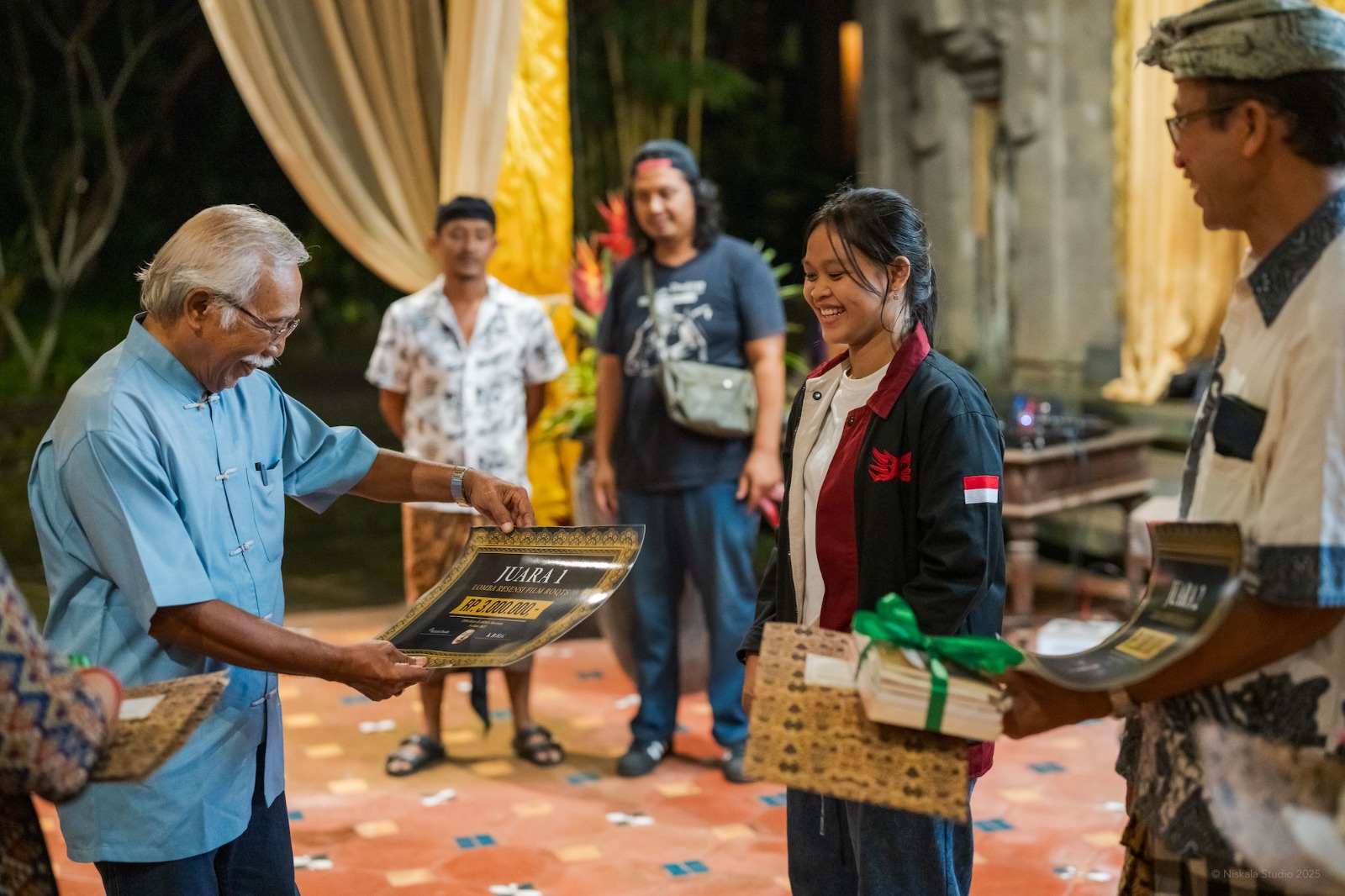 PEREMPUAN MUDA: Prof. Wayan Dibia menyerahkan piagam dan hadiah mewakili penyelenggara lomba resensi Film Roots kepada Cahya  yang menyabet juara.