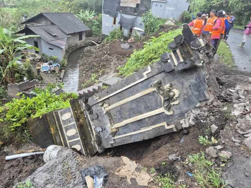 ROBOH : Kondisi gapura perbatasan di Kecamatan Pupuan yang roboh dan trotoar jalan di Pasar Bajera yang jebol. (juliadi/radar bali)