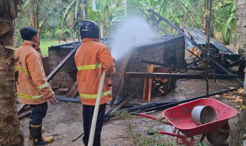 TANDAS DILALAP API: Petugas pemadam kebakaran memadamkan api. (Foto Polsek Melaya)