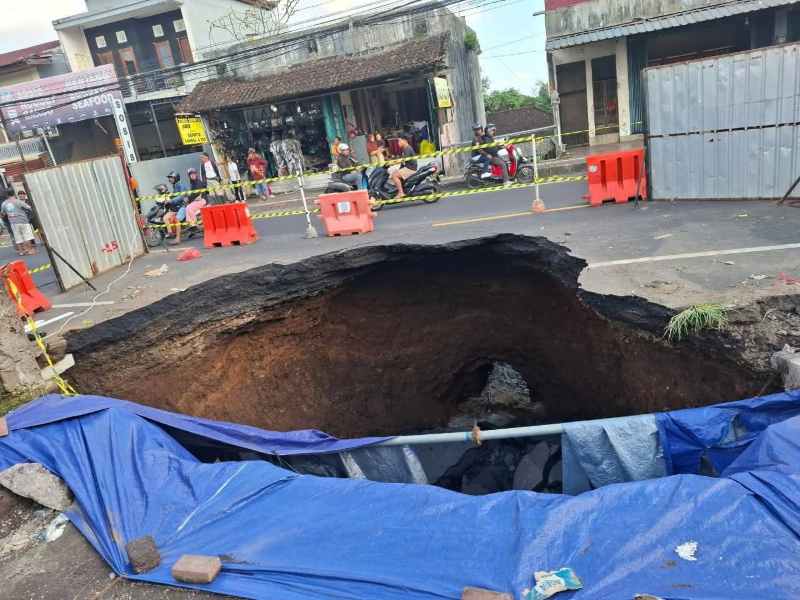AMBLES :Kondisi Jalan ambles jalur utama Denpasar-Gilimanuk berada di depan Pasar Bajera, Kecamatan Selemadeg, Tabanan. (juliadi/radar bali)
