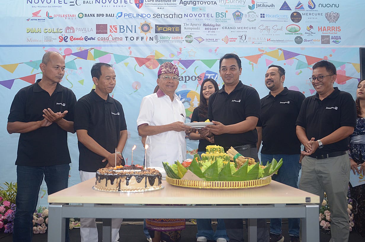 FASILITASI MEDIA: Gubernur Bali Wayan Koster memberikan tumpeng kepada Wakil Direktur Jawa Pos TV Bali, Ibnu Yunianto di halaman belakang Ktr Jawa Pos Radar Bali, Selasa 8 Juli 2025.