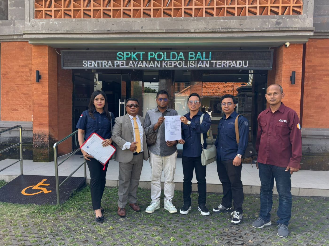 Jurnalis Jawa Pos Radar Bali Andre Sulla (tiga dari kiri) didampingi tim kuasa hukum Solidaritas Jurnalis Bali, Made "Ariel" Suardana dkk dan Benyamin Seran dan Pemred Radar Bali Djoko Heru di SPKT