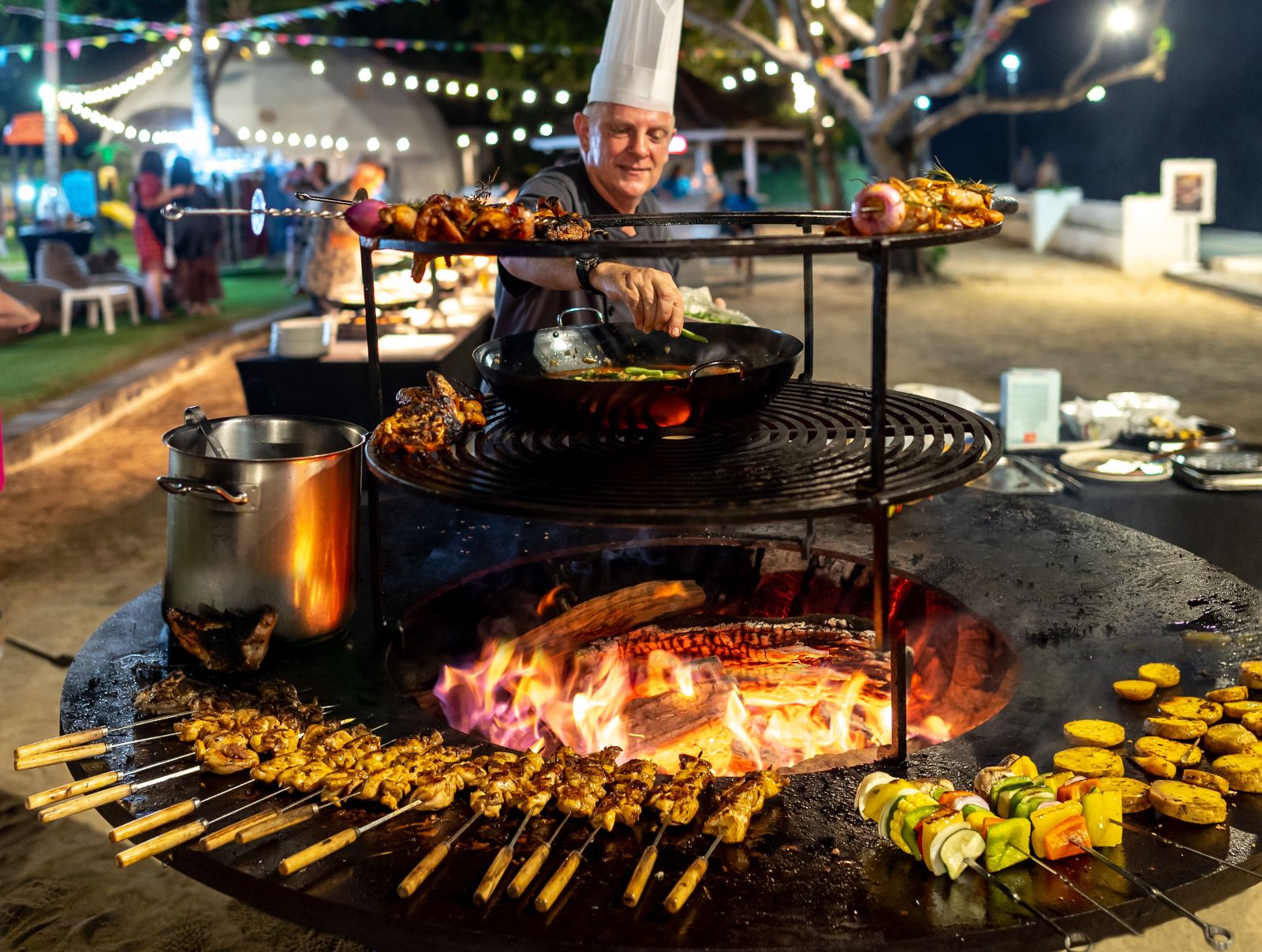ANEKA PANGGANGAN: Chef sedang mengipas dan melayani pengunjungn Perayaan Kuliner dan Budaya di Tepi Pantai Kuta
