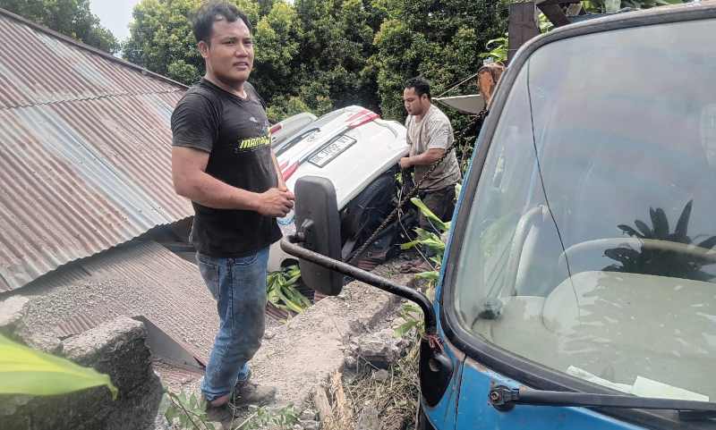 KARENA REM BLONG : Mobil yang nyemplung ke rumah warga di Desa Madenan, Tejakula, Buleleng ketika dievakuasi. (Foto: Polres Buleleng untuk Radar Bali)