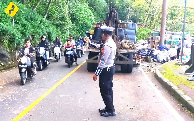 MACETKAN JALAN: Evakuasi truk yang terguling di Jalan Raya Singaraja-Denpasar di wilayah Hutan Lindung Desa Pancasari. ( Foto: Polres Buleleng untuk Radar Bali)