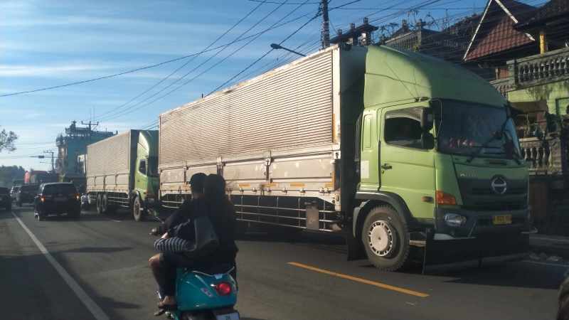 SUDAH SEDIAKALA KEMBALI : Truk-truk besar kembali bisa melintasi jalan raya yang ambles di depan Pasar Bajera, Selemadeg, Tabanan. (foto:Juliadi/Radar Bali)