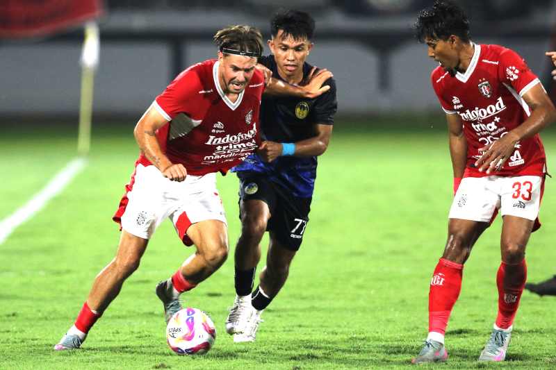 SULIT DIBENDUNG : Thijmen Goppel (kiri) ditempel ketat pemain PSIM Jogja, Kasim Botan,  di Stadion Kapten Dipta, Gianyar,  Sabtu malam  (26/7/2025). (Miftahuddin/Radar Bali)