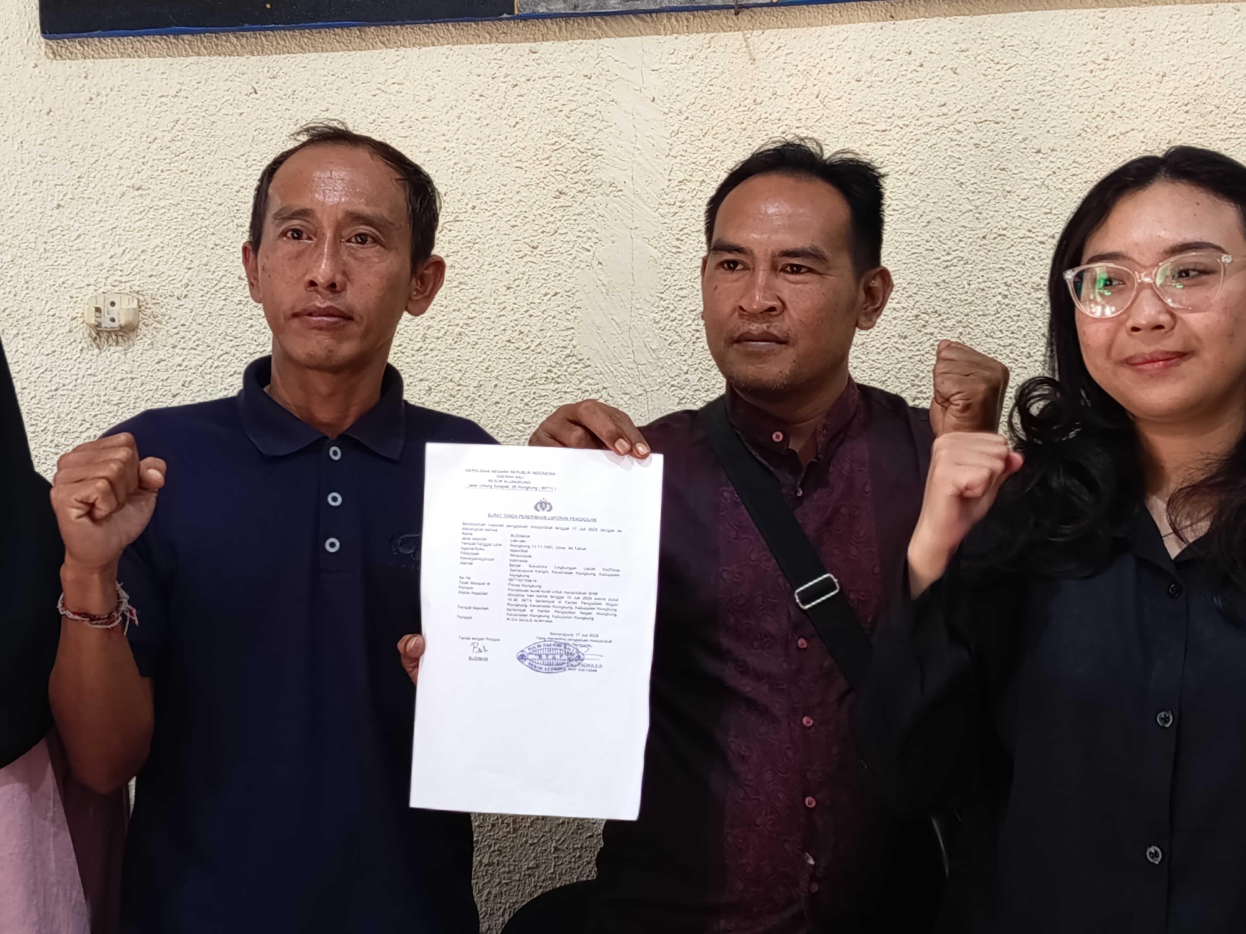 DILANJUTKAN: Budiman (tengah) menunjukkan surat laporan ke polisi.