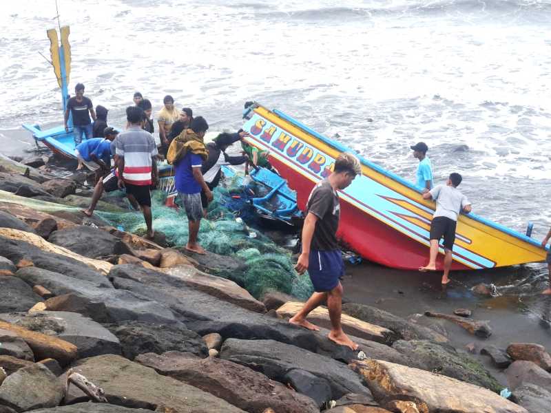 DIHAJAR OMBAK BESAR : Perahu nelayan hancur karena dihantam gelombang dan menghantam senderan pantai. (Foto: dok.pribadu Yanto)