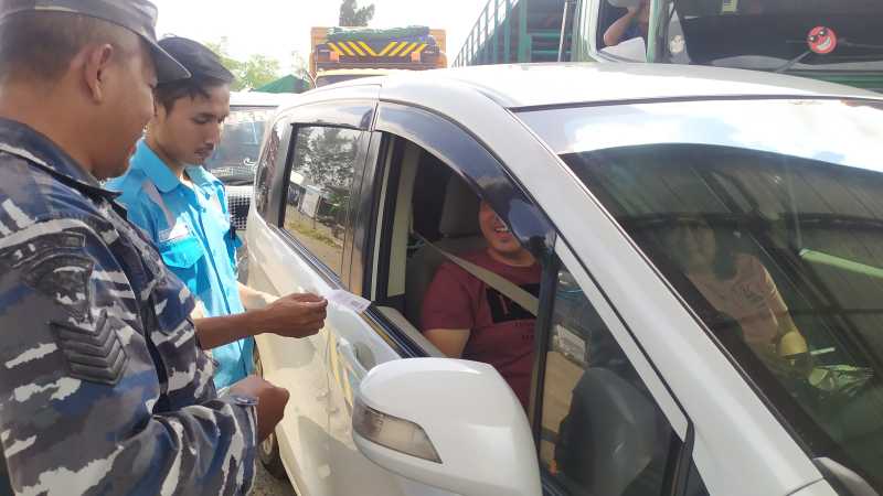 LEBIH KETAT : Petugas loket dan anggota TNI AL melakukan pemeriksaan tiket secara  detail untuk mengecek kesesuaian nama dan jumlah orang yang akan menyeberang. (m.basir/radar bali)