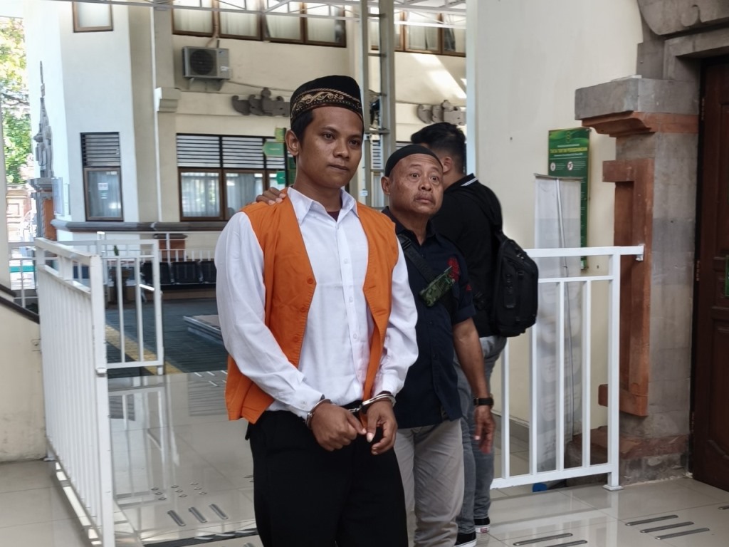 BEJAT: Ahmad Real J, terdakwa pencabulan terhadap anak tiri dibawa ke ruang tahanan usai menjalani sidang tertutup di PN Denpasar, Selasa (6/8/2025).