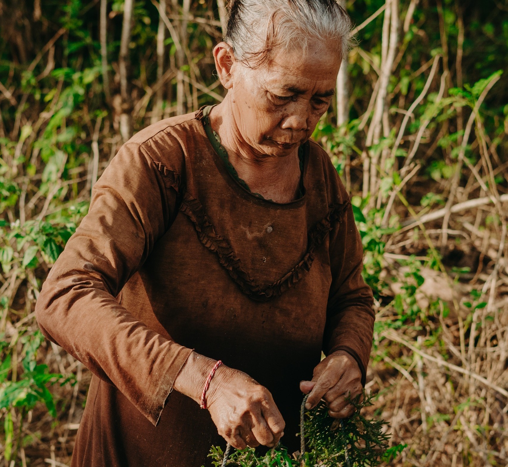 MENYATU: Dengan tangan keriputnya, Ni Made Rubeg merawat helai demi helai rumput laut. Dari Banjar Peken, Desa Serangan, perempuan tangguh ini menjadi wajah dari ketekunan dan cinta pada alam.