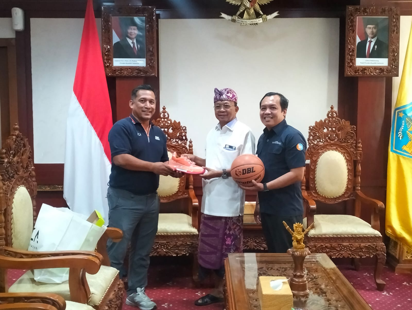 Gubernur Bali Wayan Koster  (tengah) saat menerima penyerahan  bola dan sepatu DBL 2025  oleh Wakil Direktur DBL Indonesia Donny Rahardian dan Rosihan Anwar, panitia lokal.