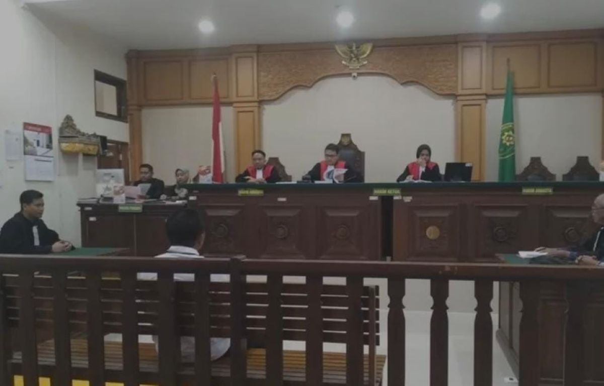 BUKAN PRODUK JURNALISTIK: Terdakwa I Putu Suardana (baju puitih) di kusi pesakitan dalam sidang pencemaran nama baik yang dipimpin hakim Regy Trihardianto.