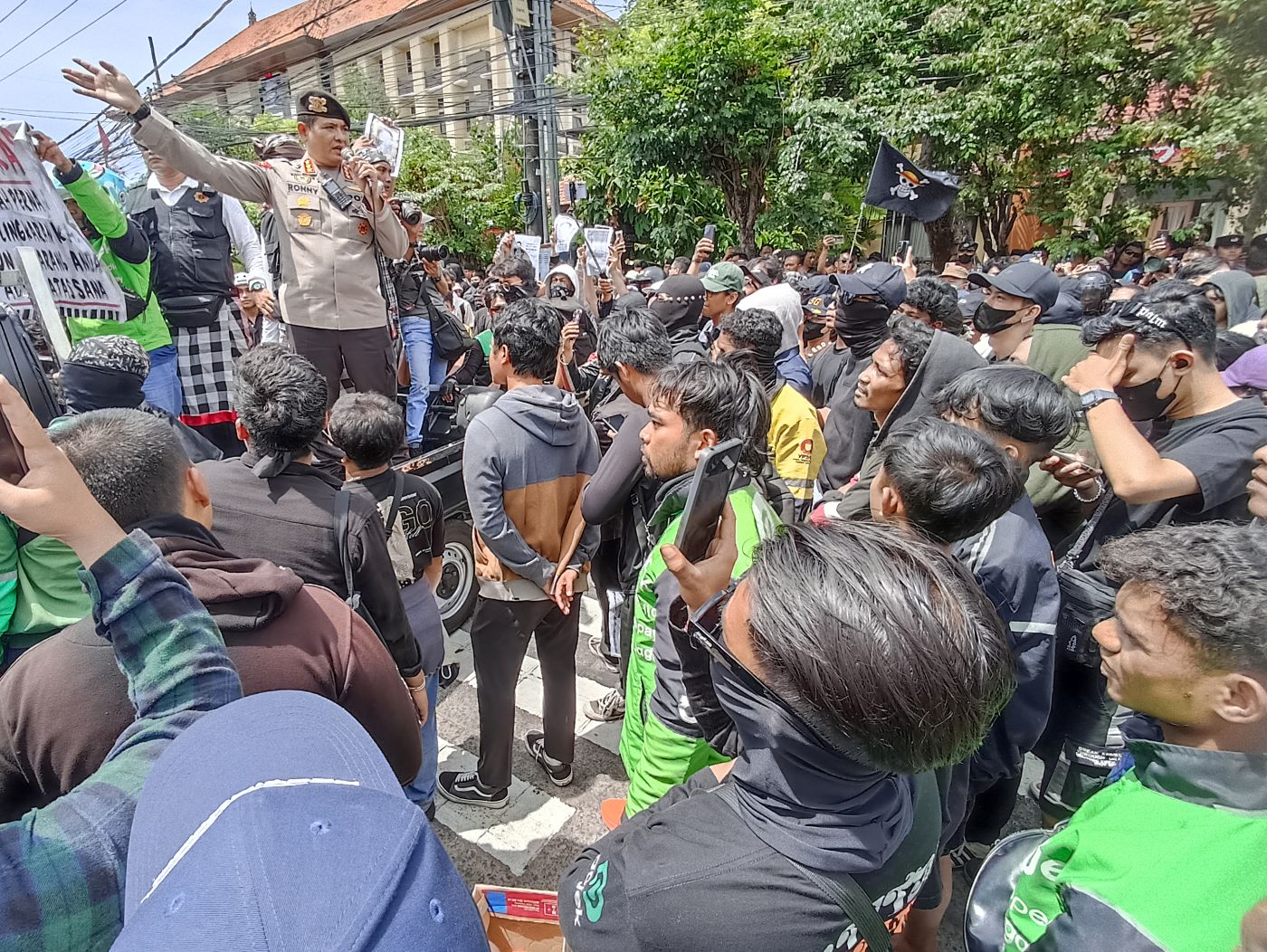 MASSA GABUNGAN: Massa ojol dan mahasisdwa serta warga berbaur di depan Mapolda Bali 30 Agustus 2025