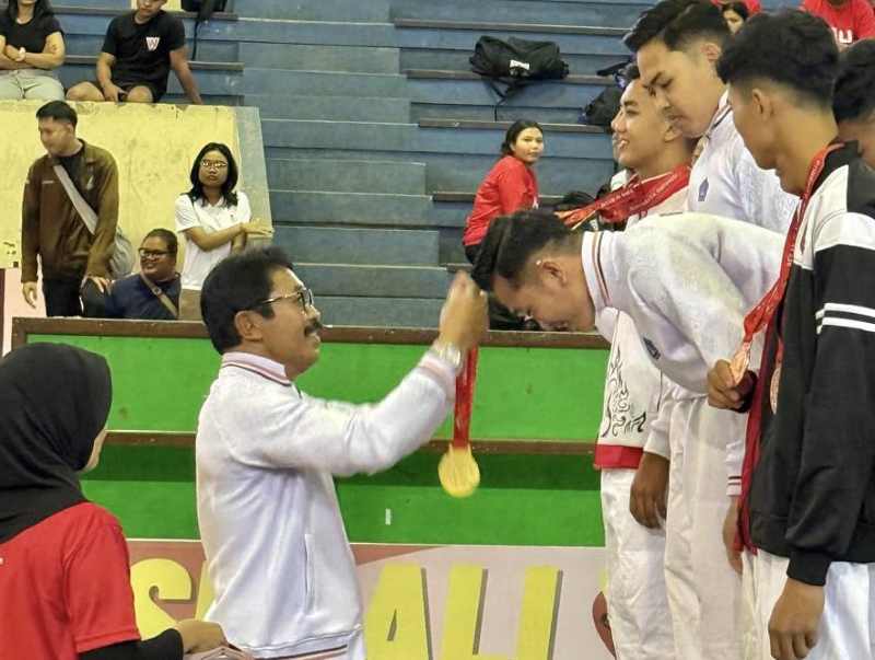 SABET MEDALI : Sekum KONI Badung, Made Sutama, mengalungkan medali emas untuk atlet judo Badung. (Foto KONI Badung untuk Radar Bali)