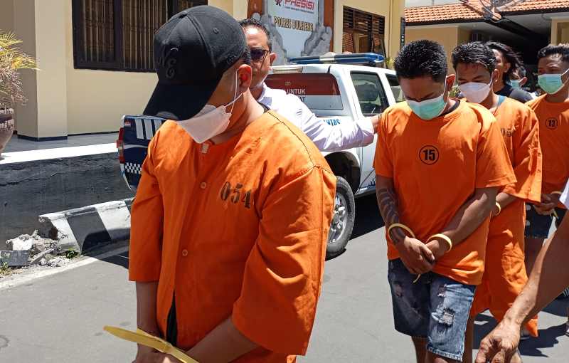 RISIKO KURIR NARKOBA: Tersangka AP tercenung sambil menutupi wajah dengan topi. (foto: francelino junior)
