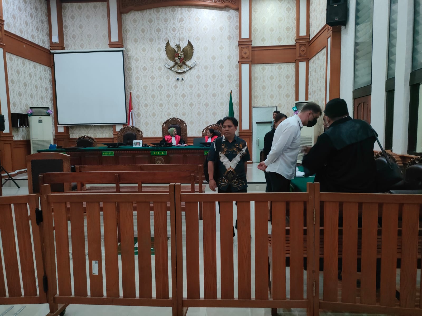 AJUKAN PEMBELAAN: Terdakwa Roman Nazarenko (baju putih) berdiskusi dengan tim pengacaranya usai melakukan pleoido di PN Denpasar, Selasa, 9 September 2025.