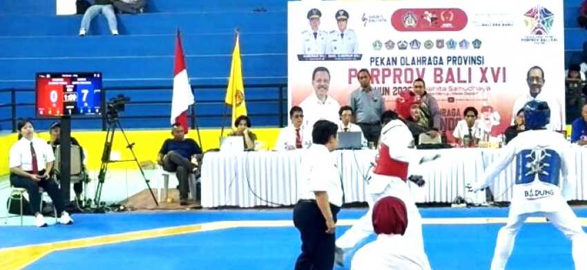 DIDOMINASI BADUNG : Atlet Taekwondo asal Badung (biru) meaning teal atas atlet Buleleng dalam final cabor TI Porprov Bali XVI 2025 di GOR Gema Putra Persada Gulingan, Mengwi.( Foto KONI Badung