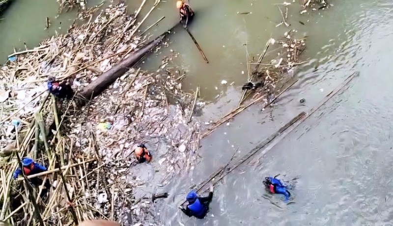 BERJIBAKU - Tim SAR gabungan Polres Badung dan Basarnas mencari jenazah korban hanyut sungai Yeh Penet di Jembatan Selingsing, Cepaka, Kediri, Tabanan.