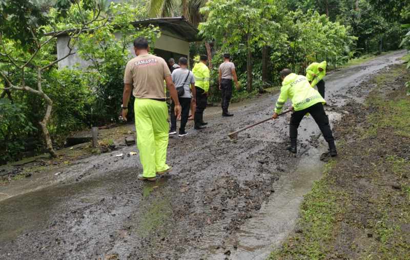 BERSIH-BERSIH JALAN RAYA : Petugas dari BPBD Klungkung membersihkan jalan yang kebanjiran. (Foto: BPBD Klungkung dan Humas Polres Klungkung)