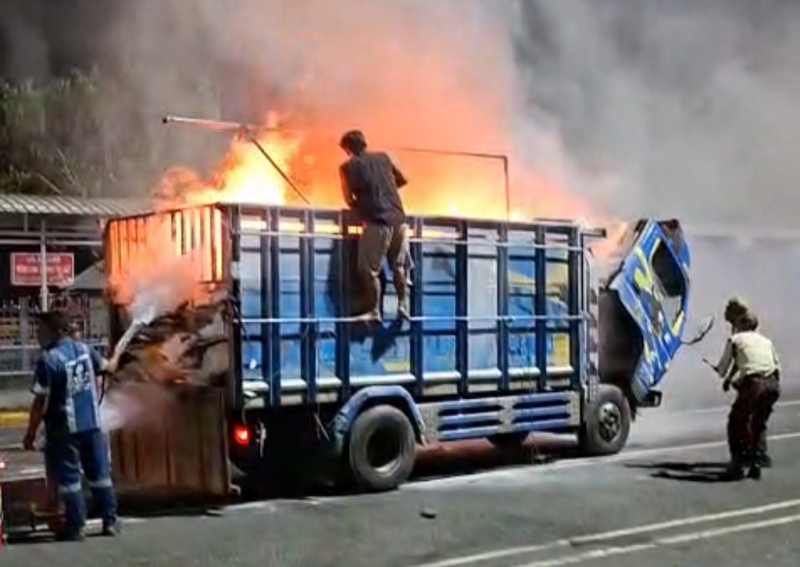 DIPADAMKAN : Tindakan pemadaman api yang membakar truk di areal Parkir Pelabuhan Gilimanuk,Jembrana. (foto: Pos AL Gilimanuk)