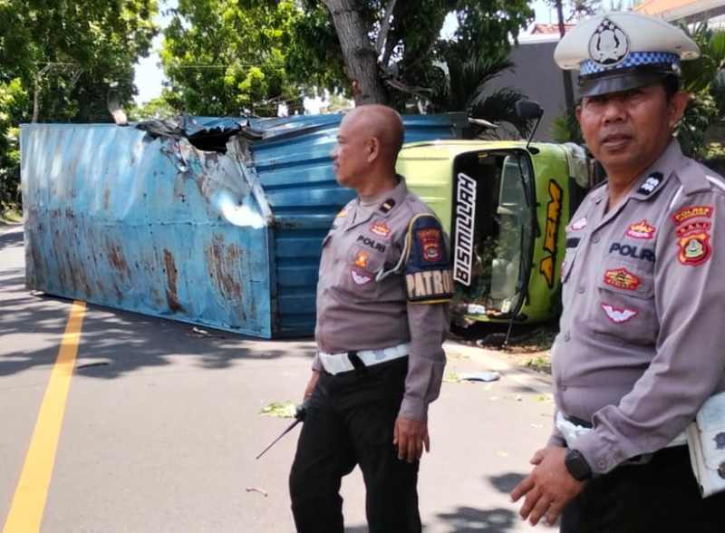 NAHAS DI JALAN RAYA: Truk terguling setelah menabrak pohon.( Foto Satlantas Jembrana)