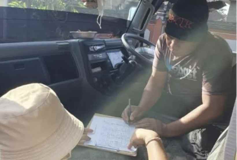 PERIKSA KETAT : Petugas melakukan pemeriksaan faktur di Pos Portal terhadap truk material yang melintas. (ist)