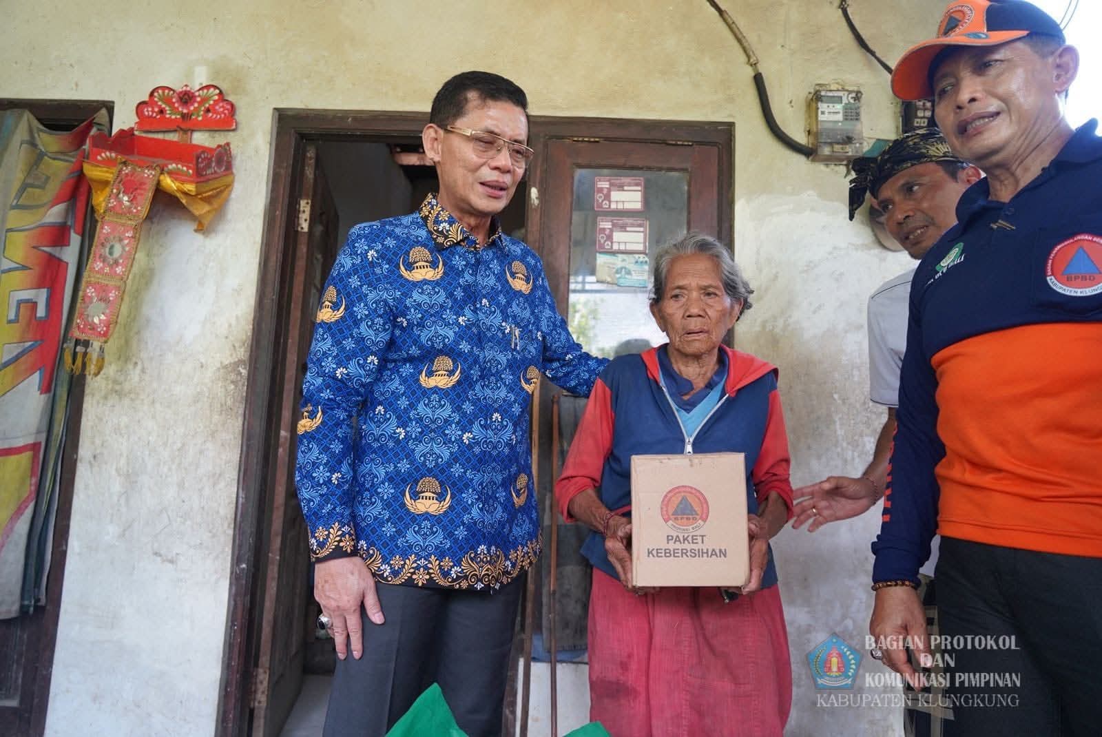 Bupati Klungkung I Made Satria bersama Kalak BPBD Klungkung Putu Widiada menyerahkan bantuan sembako kepada warga di Banjar Behu, Desa Bunga Mekar, Kecamatan Nusa Penida, Klungkung, Senin (3/11).