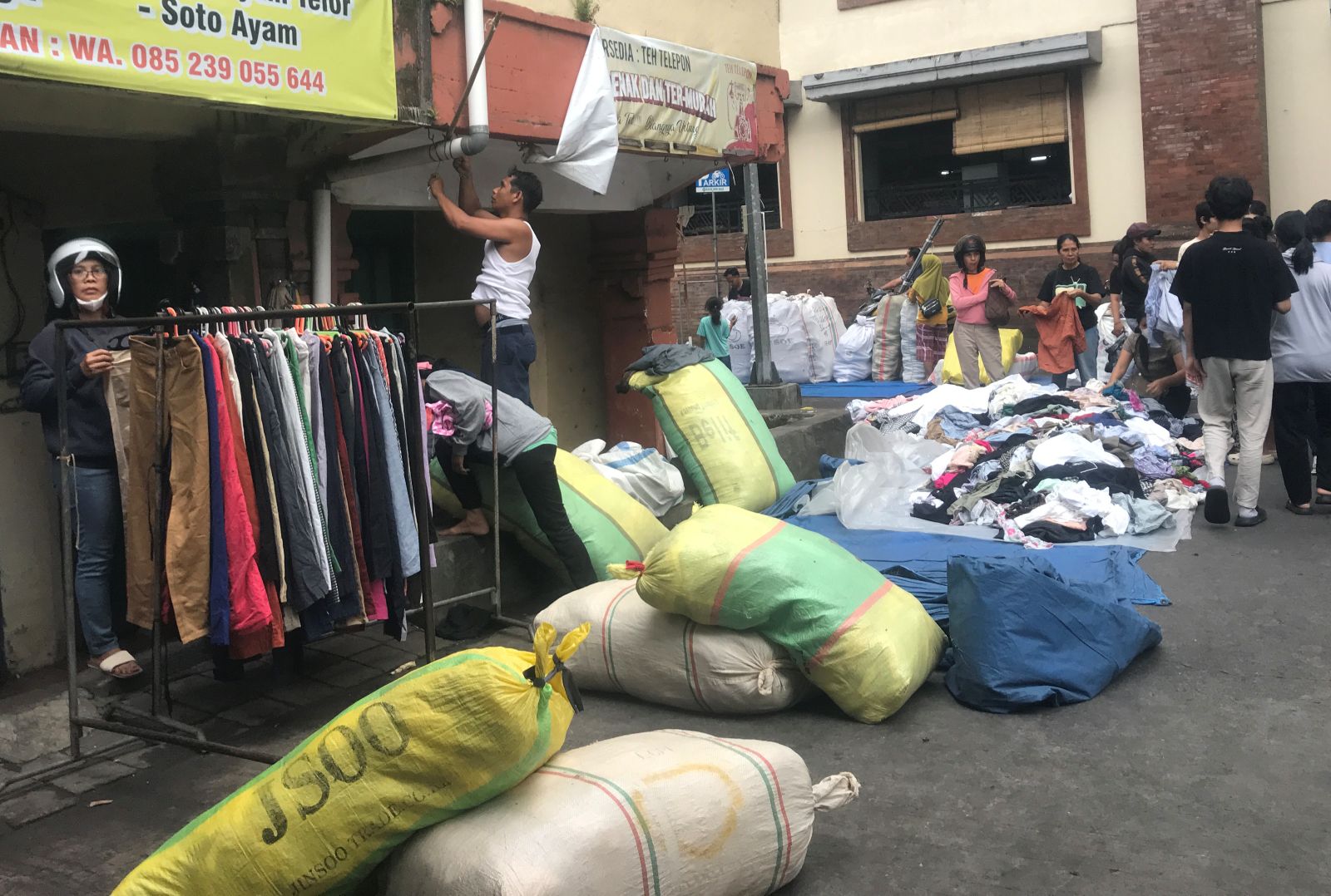 MASIH JUALAN: Pedagang baju bekas impor saat mulai buka, menata barang dagangannya di pasar Badung Minggu (2/11/2025)