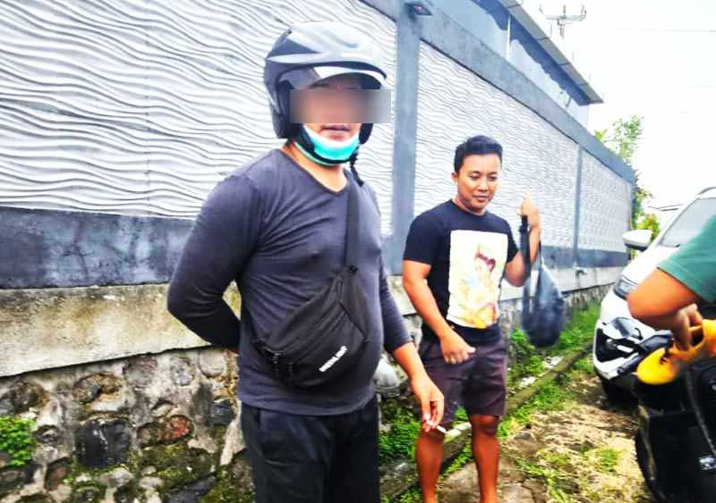 TAK BERI CONTOH BAIK : IMS, staf BNNK Buleleng (memakai helm) ketika diamankan polisi. Tes urinenya positif narkotika jenis sabu-sabu. ( Foto: Polres Buleleng untuk Radar Bali)