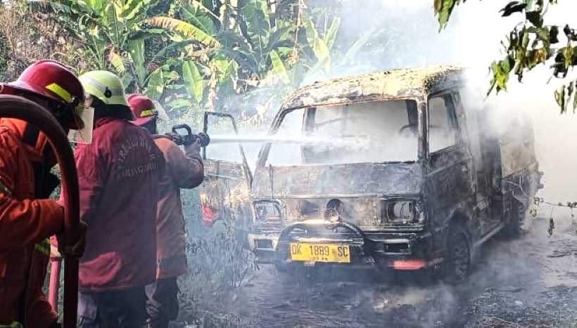 HANGUS SEMUA : Damkartan Karangasem saat melakukan pemadaman kebakaran mobil di Jalan Ahmad Yani, Subagan.(foto:Istimewa)