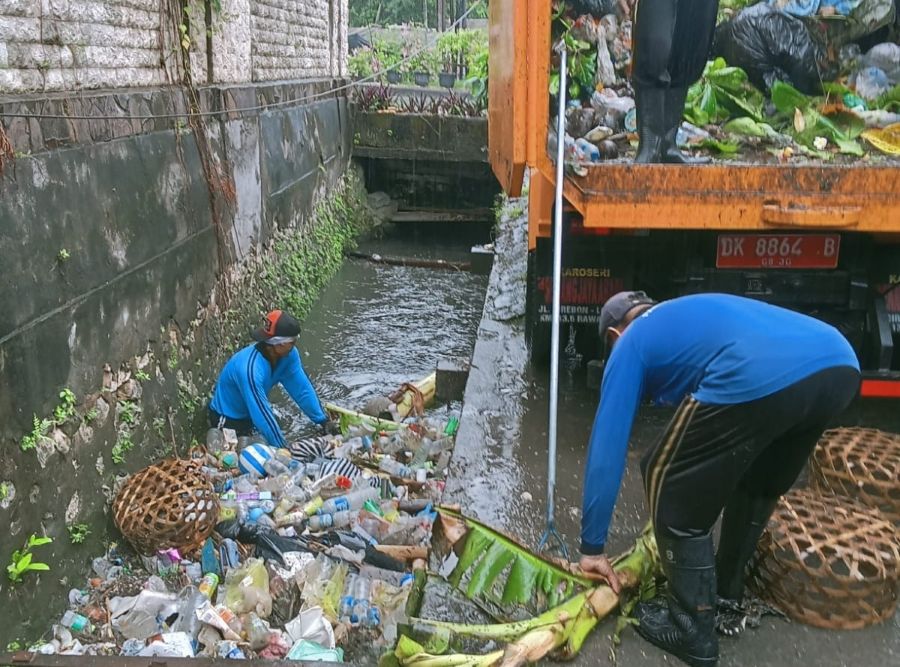 (CEGAH MAMPET: Pasukan Biru merupakan pasukan bersih-bersih saluran air Dinas Pekerjaan Umum dan Penataan Ruang (PUPR) Kota Denpasar membersihkan got-got di Kota Denpasar kemarin (9/11/2025)