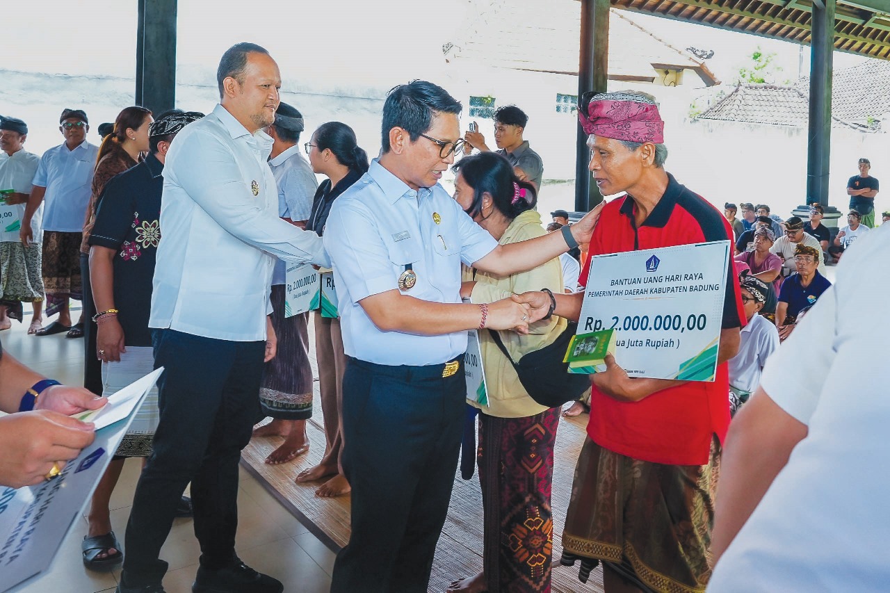 PENYERAHAN BANTUAN: Bupati Wayan Adi Arnawa bersama Wabup Bagus Alit Sucipta menyerahkan secara simbolis bantuan Rp 2 juta per KK di Wantilan Pura Dalem Khayangan Desa Adat Legian, Kuta, Rabu (12/11).