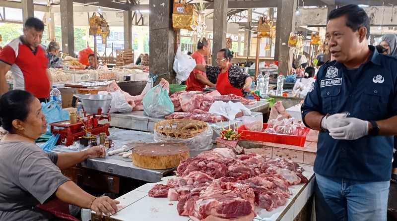 PANTAU LANGSUNG : Petugas Distan Buleleng melakukan pemantauan dan memastikan kesehatan daging babi di Pasar Anyar. (francelino junior)