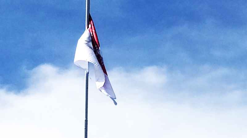 ADA TANGAN JAHIL : Bendera Merah Putih yang dirusak dengan tulisan di tiang bendera Taman Pecangakan, Kantor Bupati Jembrana. (M.Basir/Radar Bali)