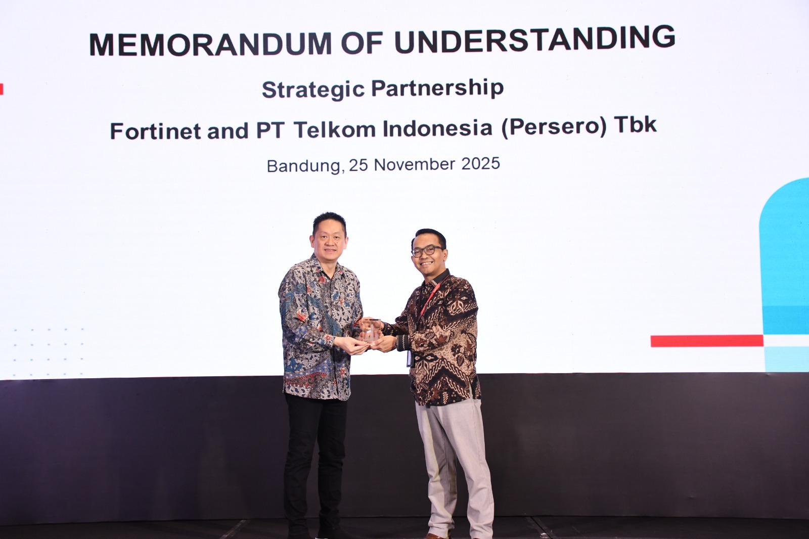 VP Global Strategic Partnership & Synergy Arfianto Ramadhian (kanan) saat memberikan cinderamata kepada Director Fortinet Indonesia Edwin Lim (kiri) pada acara seremoni  MoU antara Telkom dan Fortinet