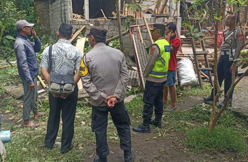 TERKENA PETIR: Petugas mengecek kondisi gudang tertimpa pohon tumbang. Meteran listrik tampak rusak terkena petir. (foto:Polsek Gianyar)
