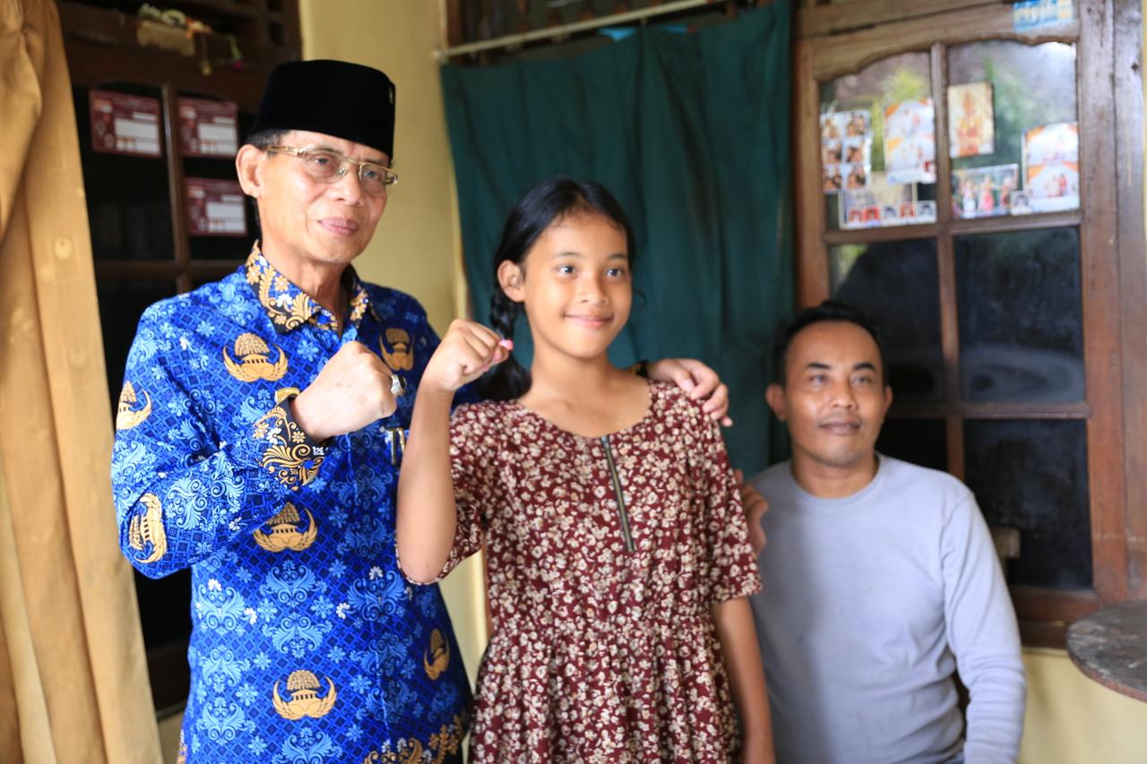 Bupati Klungkung, I Made Satria saat menyalurkan bantuan paket sembako kepada penyandang disabilitas I Putu Budiarta, 29, di Dusun Sangging, Desa Akah, Kecamatan Klungkung, Senin (1/12/2025).