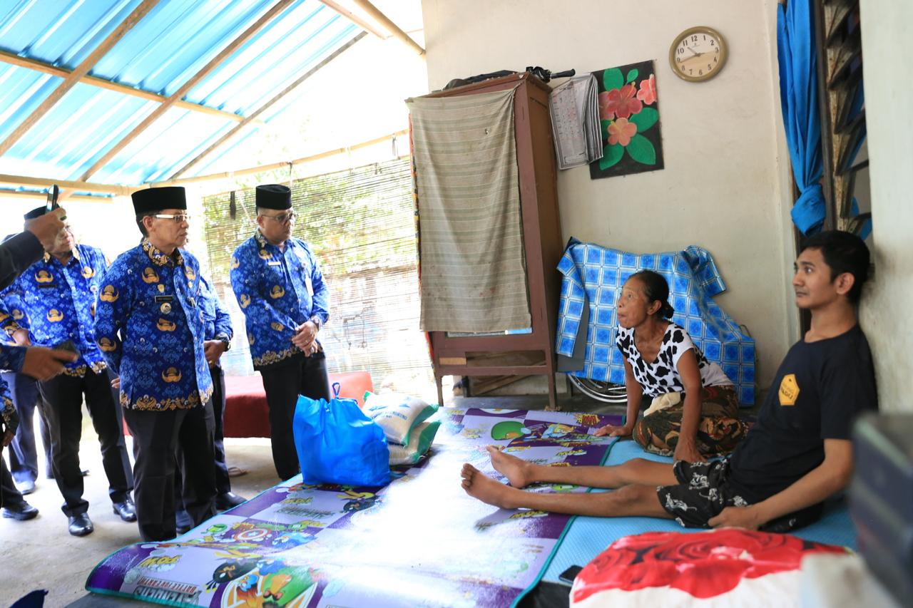 Bupati Satria menyerahkan bantuan kepada I Wayan Muliana, 26, penyandang disabilitas fisik (lumpuh) asal Desa Paksebali, Kecamatan Dawan dan Anak Agung Gede Kusuma Adnyana, 47.
