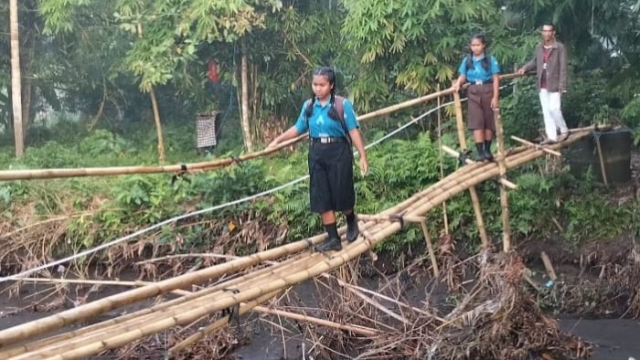 AKSES UTAMA : Sejumlah siswa  melintasi jembatan bambu, sebagai akses utama dan tercepat untuk beraktivitas. (foto: dok.Gede Dika)