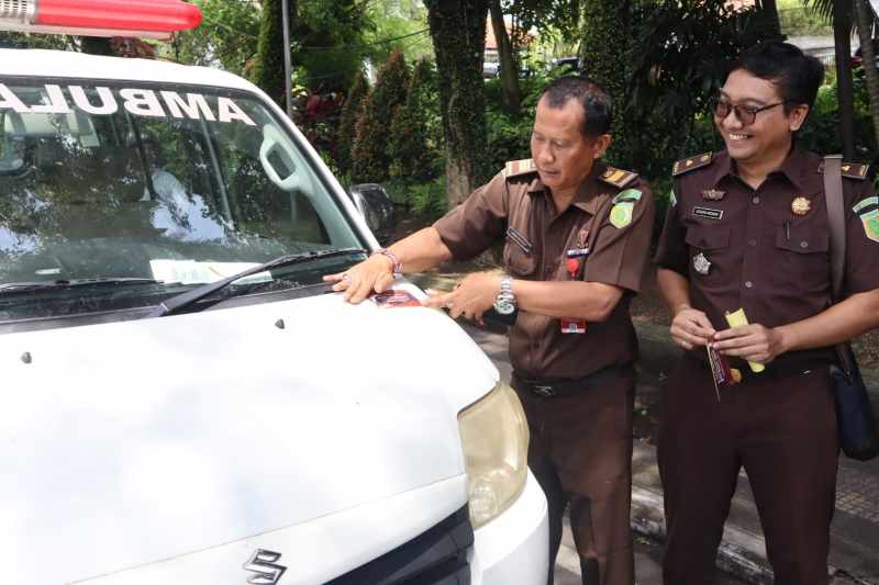 SIMBOLIS : Kejari Jembrana membagikan stiker hari antikorupsi se dunia di Jalan Sudirman. (foto: dok. Kejari Jembrana)