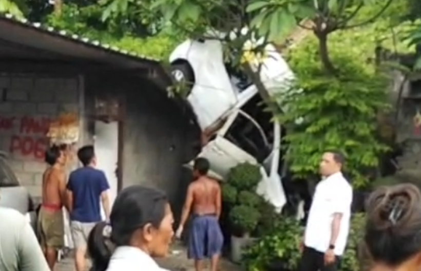 MENGAGETKAN : Mobil Honda Brio menabrak atap rumah setelah rem blong di Jalan Desa KM 16,5 wilayah Desa Tigawasa, Kecamatan Banjar, Kabupaten Buleleng. (Istimewa/Polres Buleleng)
