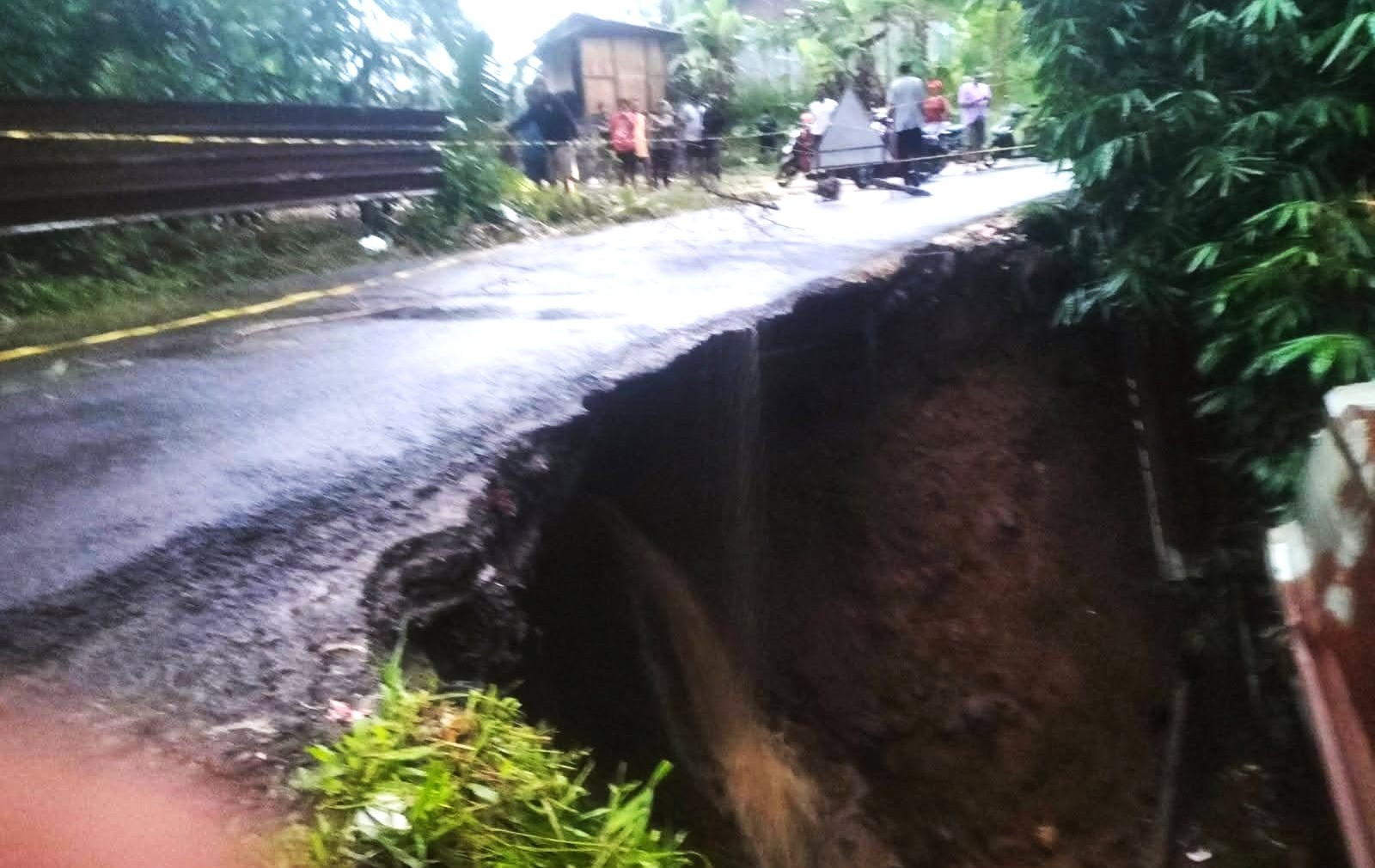 DIGERUS AIR : Kondisi jalan perbatasan antara Kabupaten Tabanan dan Kabupaten Badung Luwus-Petang yang Jebol setelah diguyur deras .(istimrea)